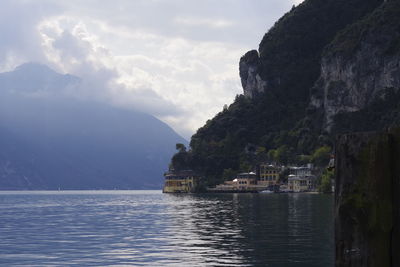 Scenic view of sea by mountains against sky