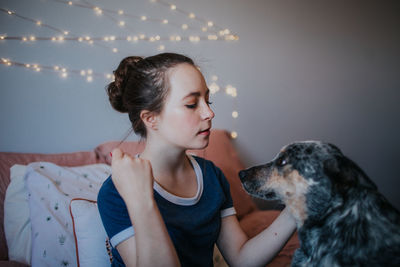 Portrait of tween girl with her dog on the bed