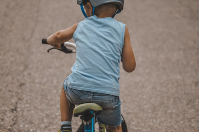 Rear view of boy riding bicycle