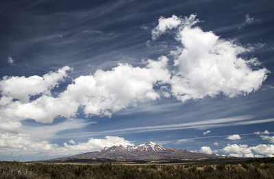 Scenic view of snow covered mountains against blue sky