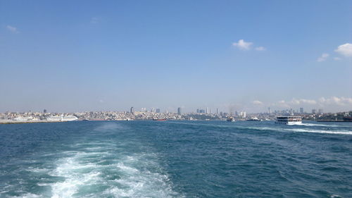Scenic view of sea by buildings against sky