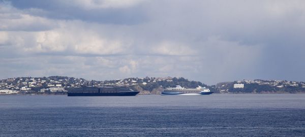 Scenic view of sea by buildings against sky