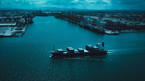 High angle view of shipping container sailing in sea and shipping terminal background cinematic