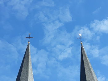 Low angle view of cross by building against sky