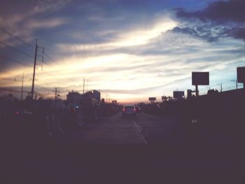 Traffic on road at sunset