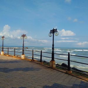 Street light by sea against sky