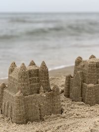 Stone wall on beach against sky