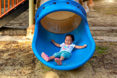 Full length of smiling girl playing in playground