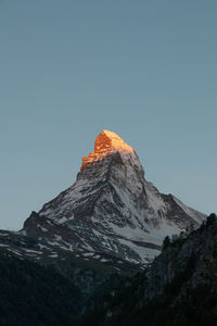 Low angle view of snowcapped mountain against clear sky