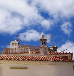 A traditional red tile rooftop with chimneys in a small portuguese town