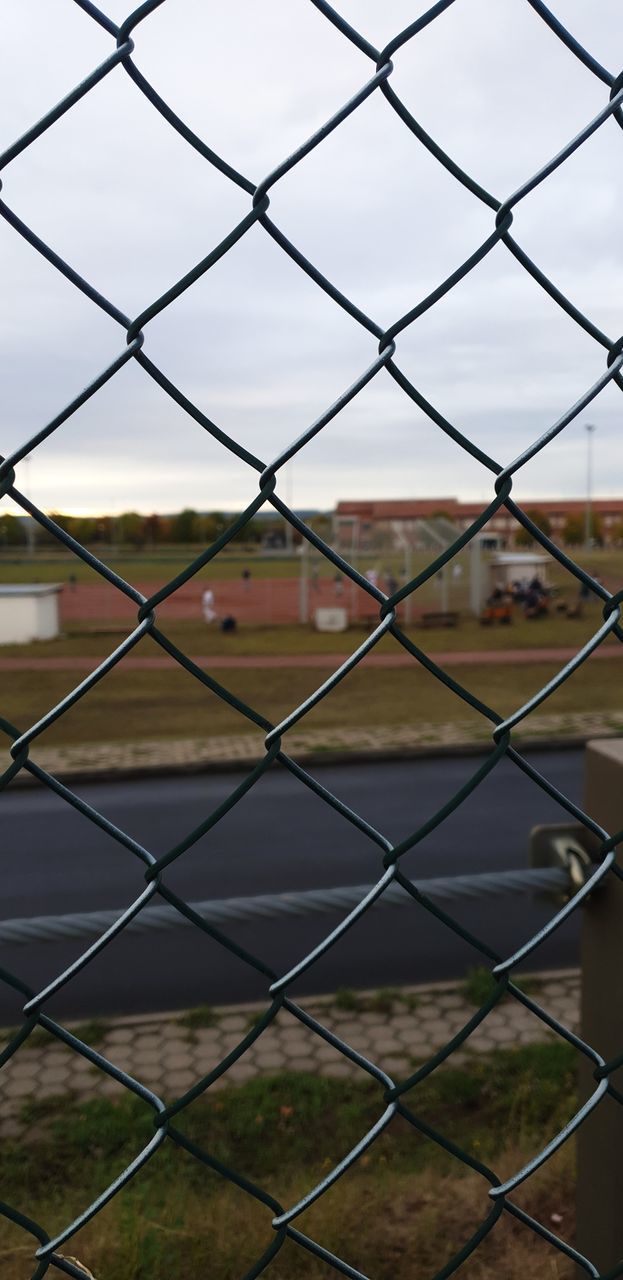 chainlink fence, fence, sport, safety, barrier, boundary, security, protection, focus on foreground, day, nature, playing field, grass, sky, backgrounds, pattern, outdoors, metal, incidental people