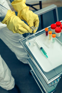 Midsection of doctor holding syringe at hospital