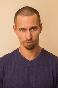 Portrait of young man standing against gray background