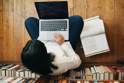 High angle view of woman using laptop at table