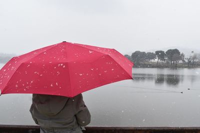 Girl holding umbrella during snowy season