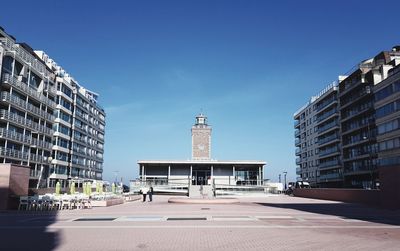 Buildings in city against blue sky