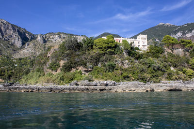 Scenic view of lake by buildings against sky