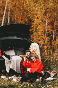 Rear view of couple sitting on field