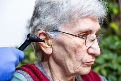 Home ear exam on senior woman
