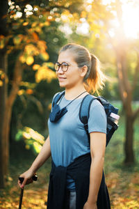 Beautiful woman standing on land against trees