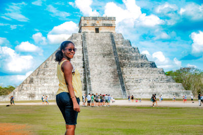 Group of people at historical building against cloudy sky