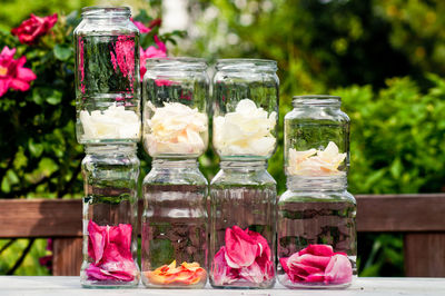 Petals in glass jars on table at yard