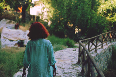 Rear view of woman standing by tree