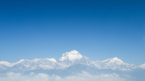 Scenic view of snowcapped mountains against clear blue sky