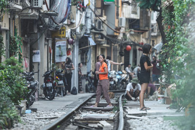 People on street amidst buildings in city