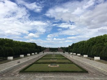 Empty road amidst trees against sky