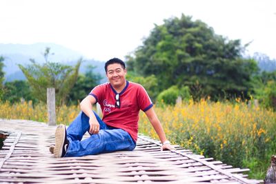 Portrait of smiling man sitting on boardwalk