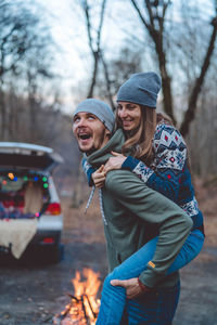 Man carrying girlfriend in forest