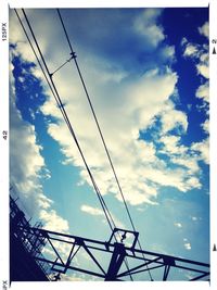 Low angle view of power lines against blue sky