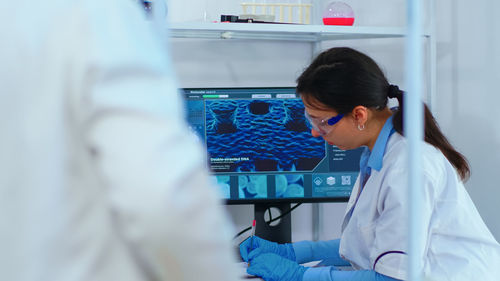 High angle view of female doctor examining patient in laboratory