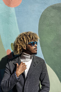 Portrait of young man wearing sunglasses standing outdoors