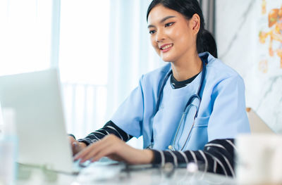 Smiling young woman using mobile phone
