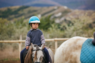 5 year old girl riding a horse with lovely expression