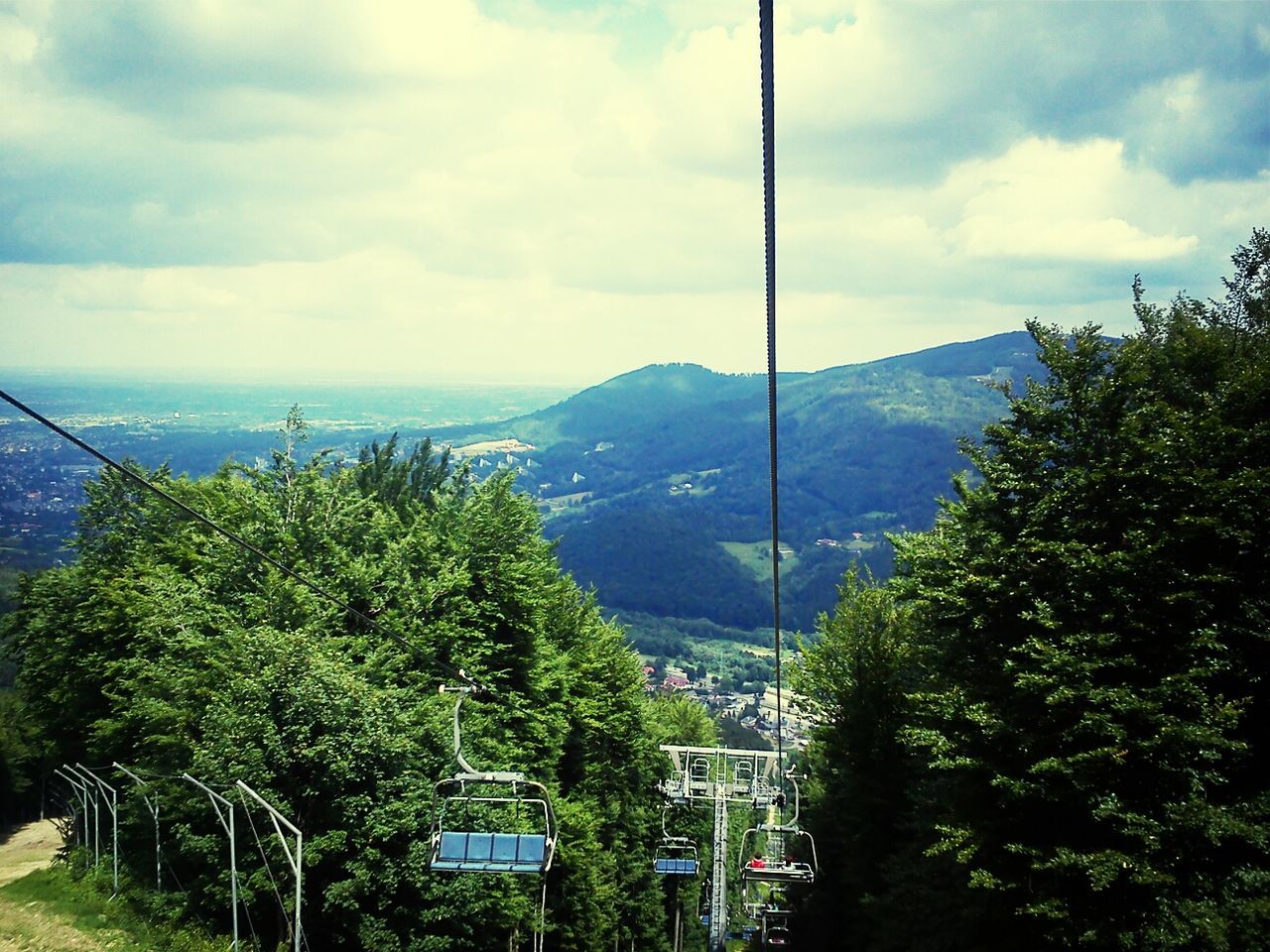 mountain, sky, tree, cloud - sky, transportation, scenics, mountain range, cloud, beauty in nature, tranquil scene, tranquility, cloudy, nature, overhead cable car, landscape, mode of transport, sea, day, water, travel