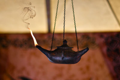 Burning oil lamp hanging at home
