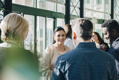 Smiling businesswoman talking to colleagues in meeting at office