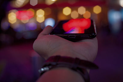 Close-up of hand holding illuminated lighting equipment
