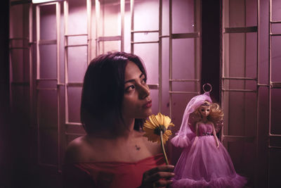 Portrait of woman holding flowers at home