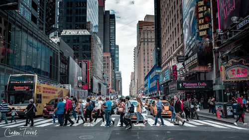 Group of people walking on road against buildings