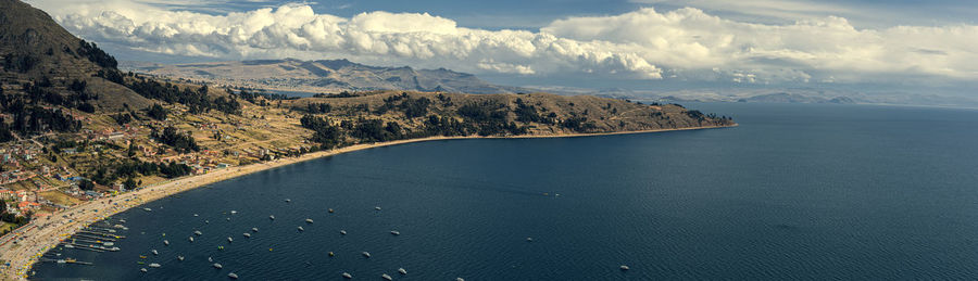 Scenic view of sea and mountains against sky