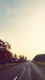 Empty road with trees in background