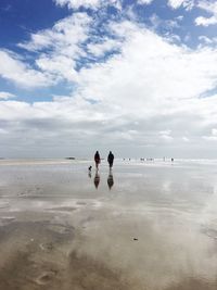 People on beach against sky