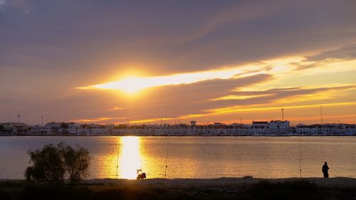 Scenic view of silhouette city against sky during sunset