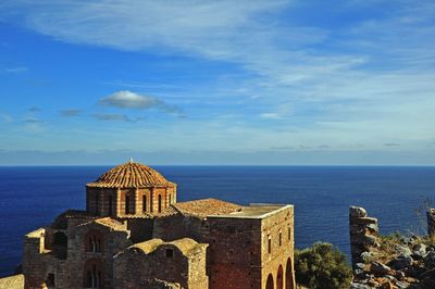 Scenic view of sea with building in foreground against sky