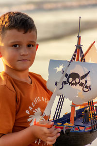 High angle portrait of boy holding paper outdoors