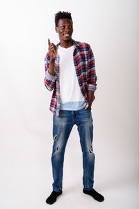 Portrait of young man standing against white background